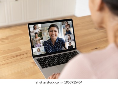 Over shoulder view of young lady sit by laptop pc screen take part in video conference psychological training for women. Diverse multiethnic group of young females meet online at virtual event webinar - Powered by Shutterstock