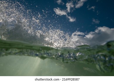 Over Under Ocean Wave View On A Sunny Day With Clear Water