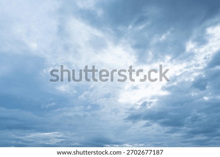 Overcast blue sky filled with dramatic thick gray and white storm clouds suggesting impending weather