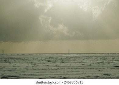 Overcast sky over snowy plain with power lines - Powered by Shutterstock