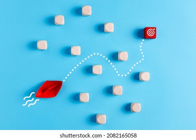 To Overcome Obstacles And To Achieve The Target Goal In Business Or Education Concept. Red Paper Boat Finds A Way Towards The Target Icon.