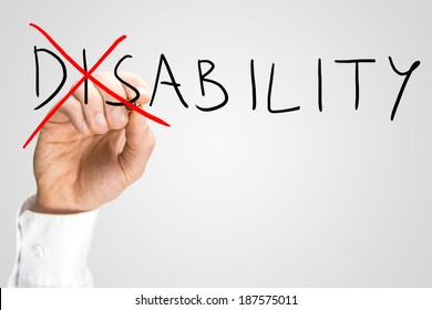 Overcoming A Disability Concept With A Man Writing The Word Disability On A Virtual Interface And Then Crossing Through The - Dis - With A Red Marker Pen As A Motivational Call To Overcome Adversity.