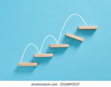 Overcoming obstacles and problem solving in business or career growth concept. White line forming increasing graph over wooden blocks on blue background.