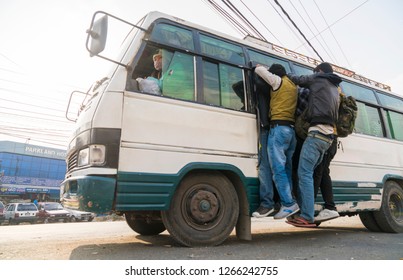 Overcrowded bus with people gripping its doors. Fuel crisis in Nepal. Captured in Nepal in winter 2015