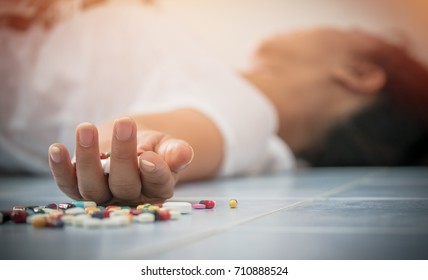 Overdose - close up of pills and addict lying on the floor