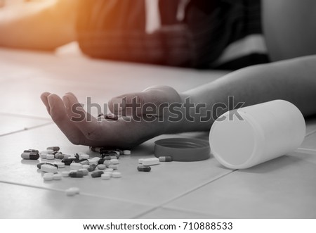 Overdose - close up of pills and addict lying on the floor
