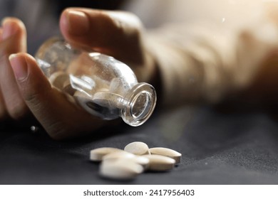 overdose teenager holding bottle and pills coming out of bottle,overdose concept,health,juvenile delinquency,narcotics. dramatic concept photo.