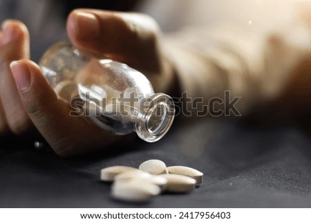 overdose teenager holding bottle and pills coming out of bottle,overdose concept,health,juvenile delinquency,narcotics. dramatic concept photo.