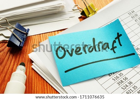 Overdraft sign and stack of accounting documents.