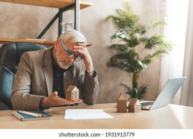 Overdue Mortgage Payment. Senior Man Holding A Model House In His Hands In Despair. Pledged Housing, Problems With The House.