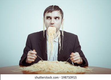 Overeating and consumerism concept. Silly nasty businessman eating pasta.