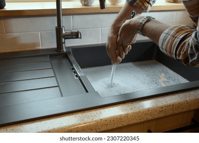 Overflowing kitchen sink, clogged drain, plumbing problems, trying to unclog - Powered by Shutterstock