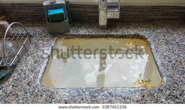 Overflowing kitchen sink, clogged drain.\
Plumbing problems.