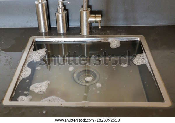 Overflowing kitchen sink, clogged drain.\
Plumbing problems.