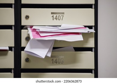 An Overflowing Mailbox In The Lobby Of An Apartment Building. Mailboxes Full Of Letters With Apartment Numbers