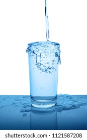 overflowing mineral water in transparent glass with drops and bubbles isolated over white, blue background, close up
