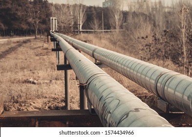 Overground heat pipes. Pipeline above the earth conducting heat for heating city. Warm autumn day. Toned photo.