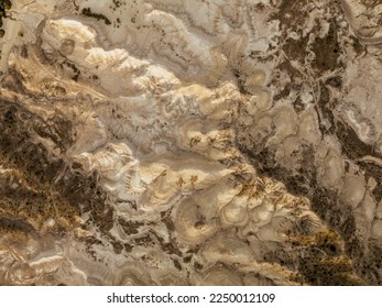 Overhead aerial shot of a yellowish moonscape in remote location desert area. Golden hour sunset view. Valle de la Luna Amarillo, General Roca, Rio Negro - Powered by Shutterstock