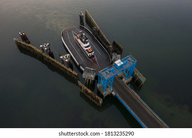 Overhead Aerial View Of A Small Ferryboat Docking On Lummi Island. The 21 Car Ferry Services This Small Island Near The City Of Bellingham In The Salish Sea Area Of The Pacific Northwest.