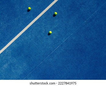 Overhead aerial view of three balls near the net of a blue paddle tennis court, sports courts - Shutterstock ID 2227841975