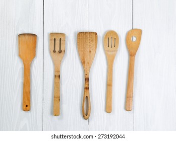 Overhead Angled Shot Of Wooden Spatula, Spoons On White Wood. Format In Horizontal Layout. 