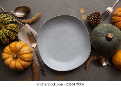 Overhead Autumn Thanksgiving Dinner Place Setting With Pumpkins Cutlery And An Empty Plate