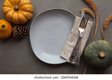 Overhead Autumn Thanksgiving Dinner Place Setting With Pumpkins Cutlery And An Empty Plate