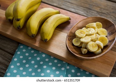 Overhead Of Banana And Slices Of Banana In Plate Kept On Chopping Board