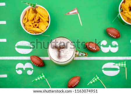 overhead beer and snacks on table decorated for the big football game