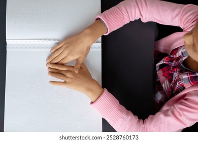 Overhead of blind, biracial schoolgirl sitting at desk reading braille in class with copy space. Education, childhood, elementary school, inclusivity and learning concept. - Powered by Shutterstock