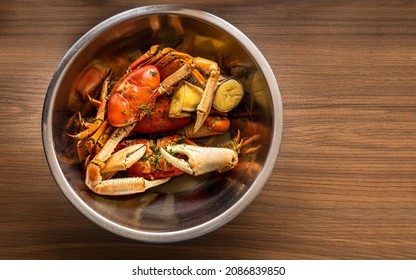 Overhead Of A Bowl With Crabs Cooking On A Wooden Background