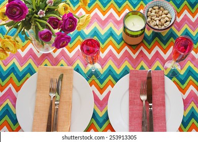 Overhead Bright Colorful Table Setting With Multi-colored Chevron Pattern Tablecloth