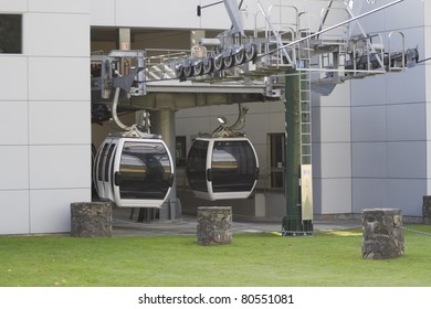 Overhead Cable Cars Entering And Exiting Building