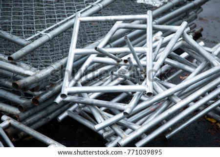 Overhead close up on rectangle metal support bases and galvanized steel footings for temporary chainlink fence at a construction site