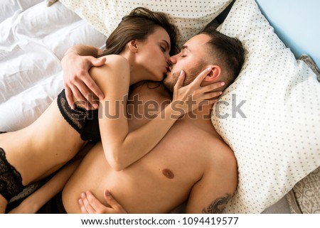 Similar – Young couple in love embracing lying over a bed