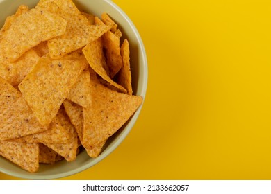 Overhead Close-up Of Nacho Chips In Bowl On Yellow Background With Copy Space. Unaltered, Unhealthy Food, Snack And Crunchy Snack.