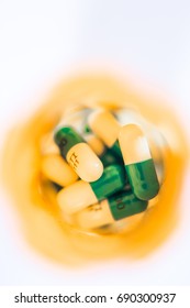 Overhead And Closeup Of White And Blue Pills Or Capsules In Orange Prescription Bottle