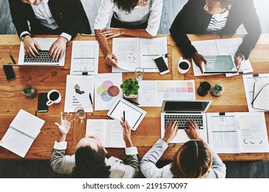 Overhead of colleagues having a marketing meeting in modern office. Above a busy workplace, coworkers brainstorm and develop strategies for a startup business, unity, planning and innovation at work - Shutterstock ID 2191570097