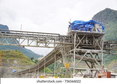 Overhead Conveyor Belt For Concrete Transportation In Very Large Construction Site With Warning Sign In Lao And English Language 