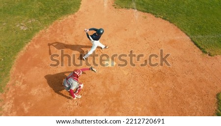 OVERHEAD CRANE Batter baseball player hits a ball over a home plate