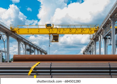 overhead cranes over railroad in metal pipe outdoor warehouse