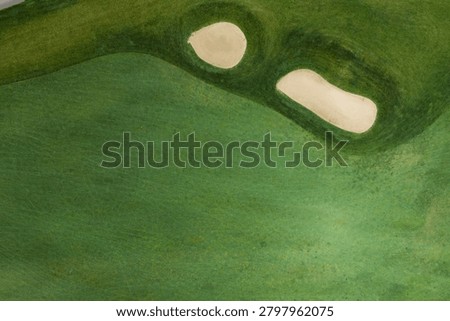 Overhead drone perspective of a well-maintained golf course fairway with two sand bunkers strategically positioned along the hole in Elgin, Illinois.