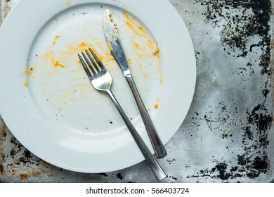 Overhead Of An Empty Plate With Fork And Knife Left Dirty After A Meal With Copy Space