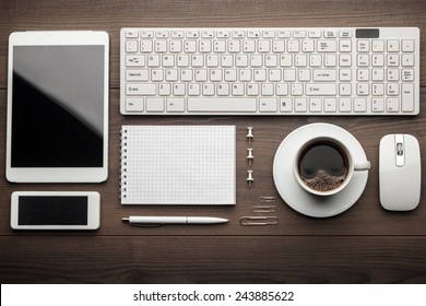 overhead of essential office objects in order on wooden desk - Shutterstock ID 243885622