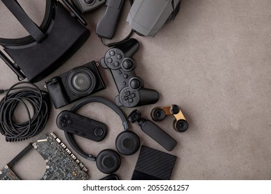 Overhead flat lay of black technology devices and gadgets on a grey background - Shutterstock ID 2055261257