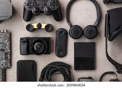 Overhead flat lay of black technology devices and gadgets on a grey background - Shutterstock ID 2059843034