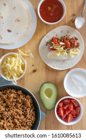 Overhead Flat Lay Of Tacos For Dinner With Ground Mince Beef Cheese Hot Sauce Avocado Tomato And Sour Cream On Warm Tortillas