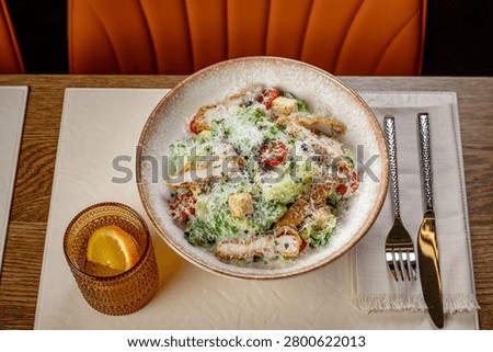 Overhead flat lay view of classic Caesar salad with chicken. Flat lay technical image of Caesar salad with grilled chicken, parmesan cheese, croutons, and tomatoes in a bowl.