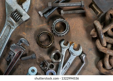 Overhead Flat Lay View Of Industrial Standard Professional Engineering Equipment Including Wrenches And Spanners As Well As Chains Bearings Bolts Washers And Screws On A Wooden Work Bench Surface