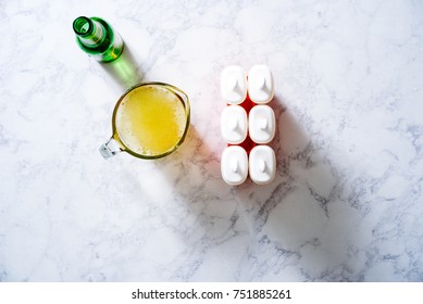 Overhead Of Ginger Simple Syrup For A Moscow Mule Popsicle With Ginger Ale On A White Marble Surface.